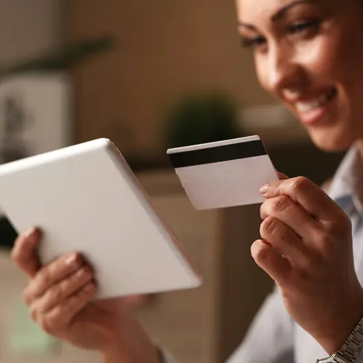 Frau mit Kreditkarte und Tablet in der Hand