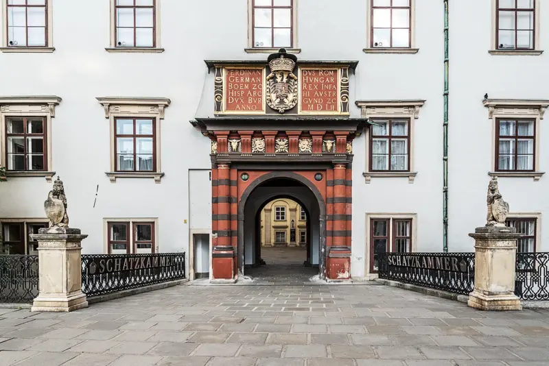 Das Schweizertor in der Wiener Hofburg Historisches Tor der Wiener Hofburg, das sogenannte Schweizertor, mit roter und schwarzer Steinverzierung sowie goldenen Wappen- und Inschriftenfeldern; Zugang zur Schatzkammer des Bundesdenkmalamts.